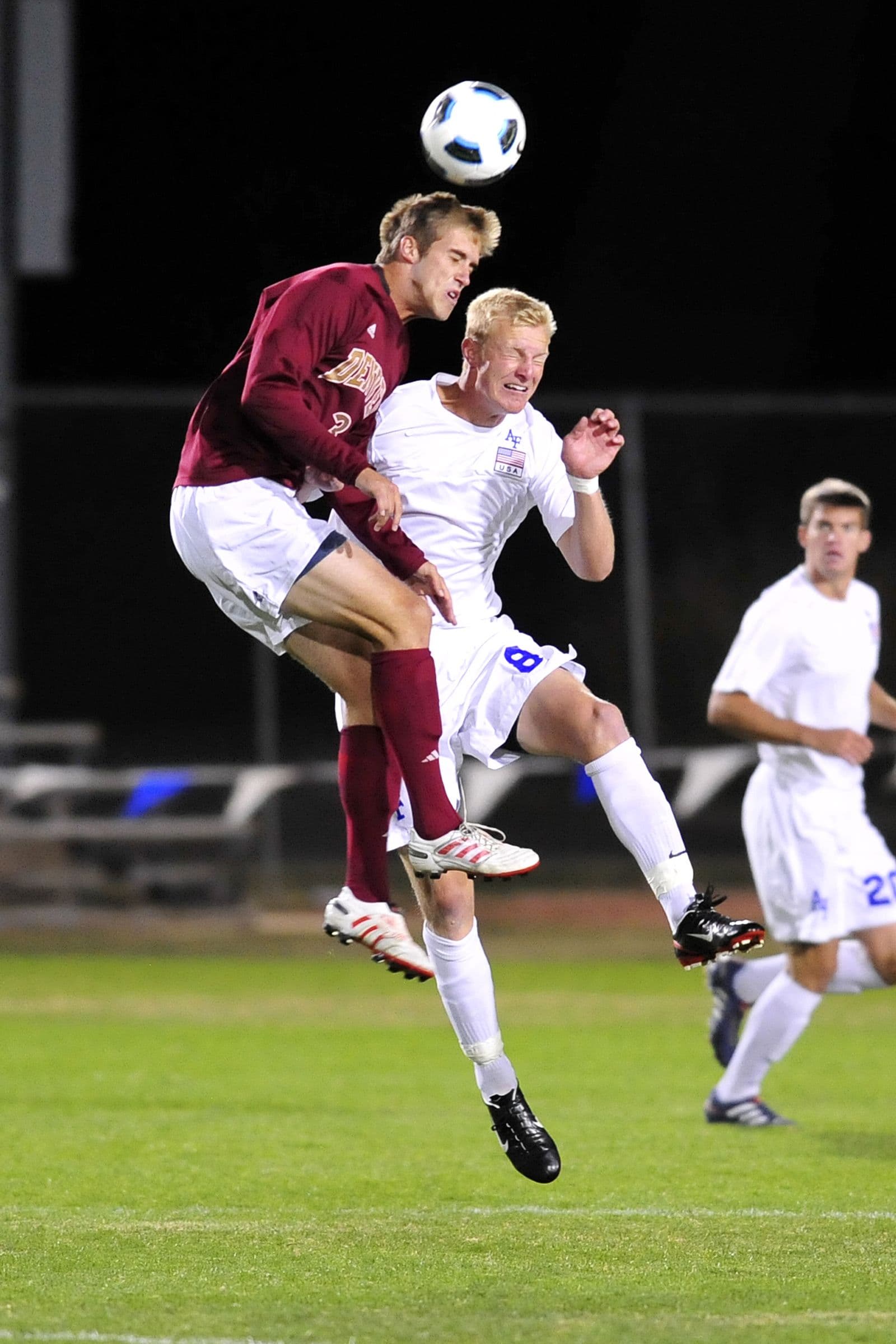 A Denver and an Air Force men's player jumping together for a header